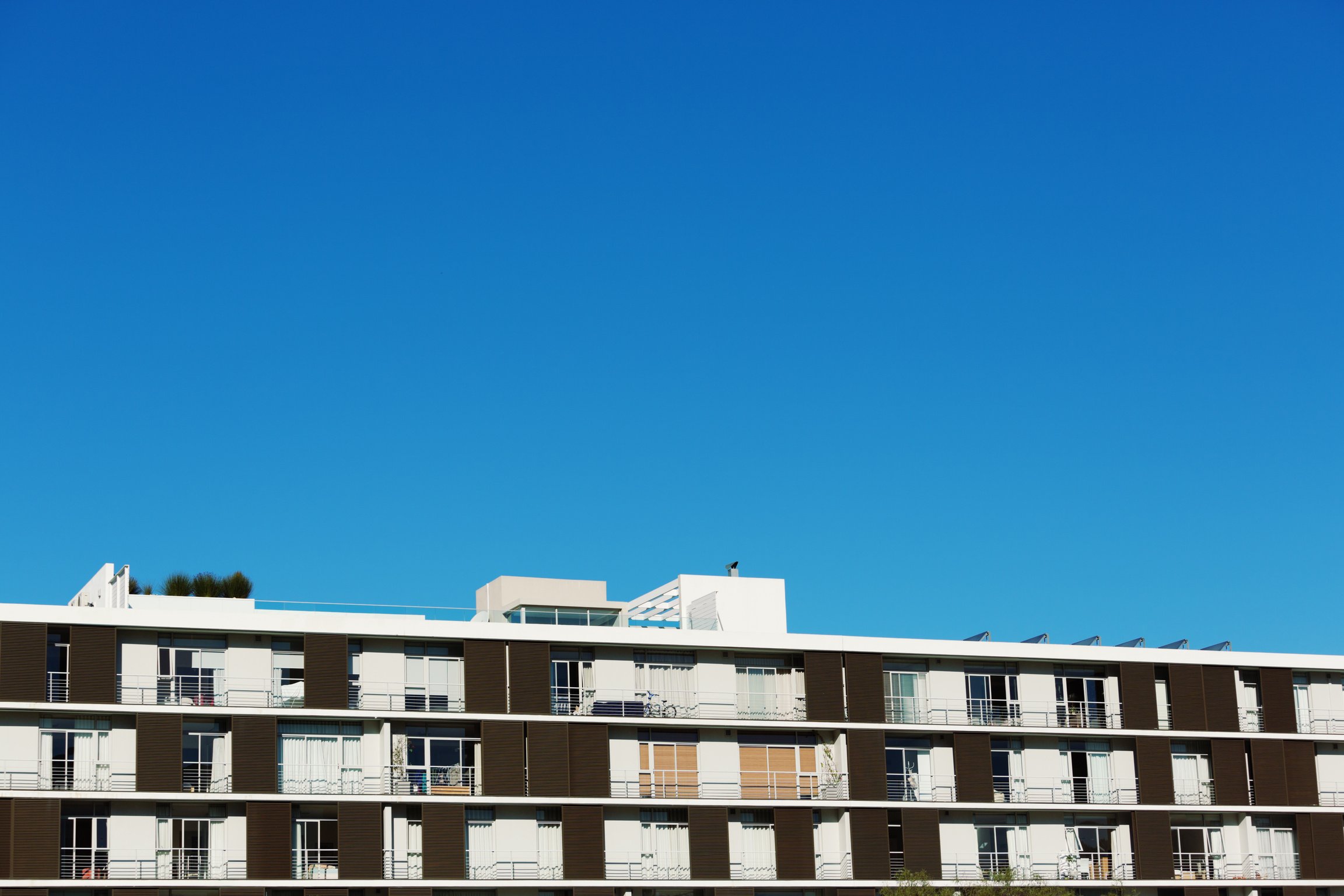 Low-rise modern apartment block against clear blue sky